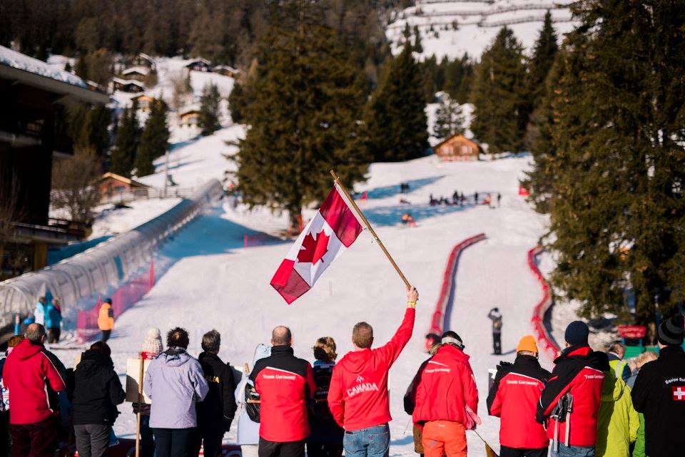 Parents watching kids ski down a hill
